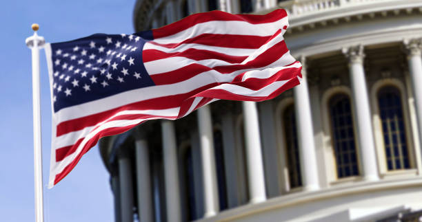 American flag waving in front of the US Capitol